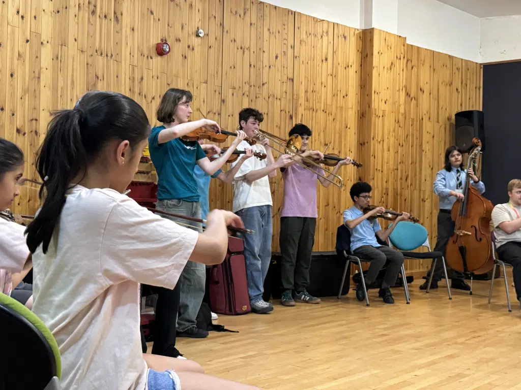 Three young musicians from the NYO performing with young musicians on the connect programme.