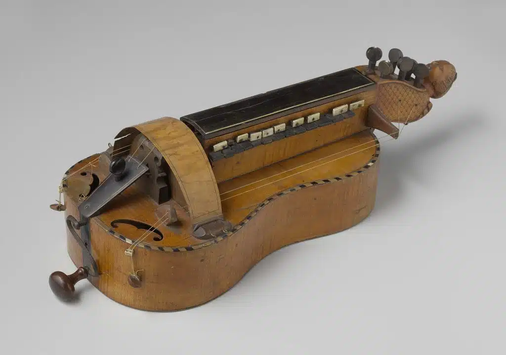 Hurdy gurdy (uncommon instrument) on a white floor.