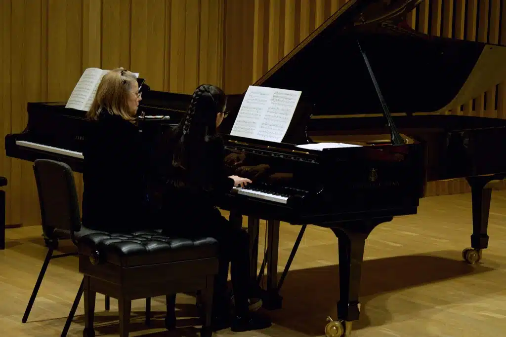 Kathryn Stott and a young pianist playing a piano duet at Young Sounds UK's Thrive Piano Masterclass at Chetham's School of Music